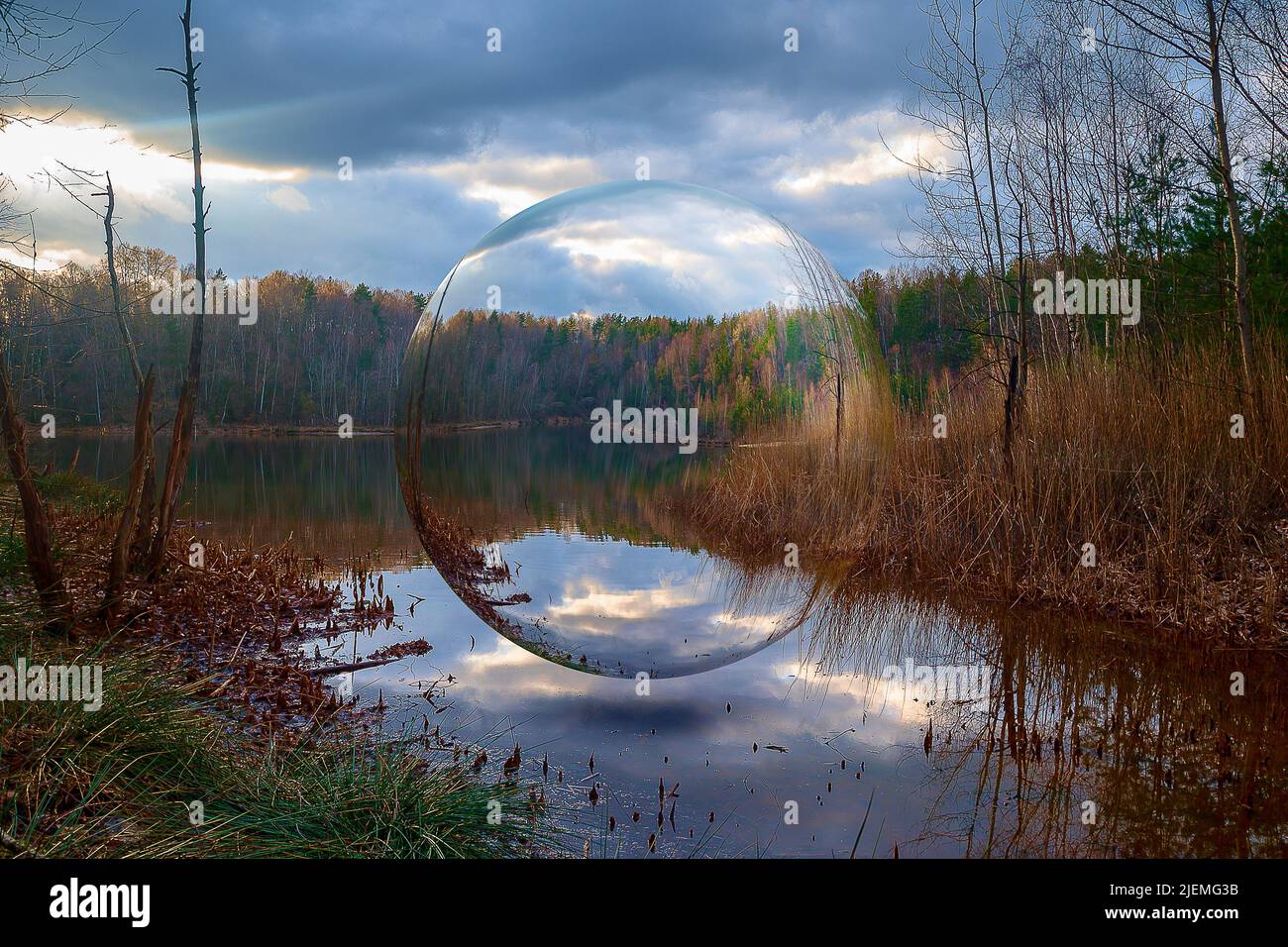 una palla di vetro si aggira su un lago in un paesaggio idilliaco e bellissimo Foto Stock