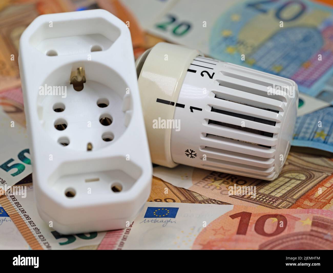 Termostato davanti alle banconote, simbolo dei costi di riscaldamento Foto Stock