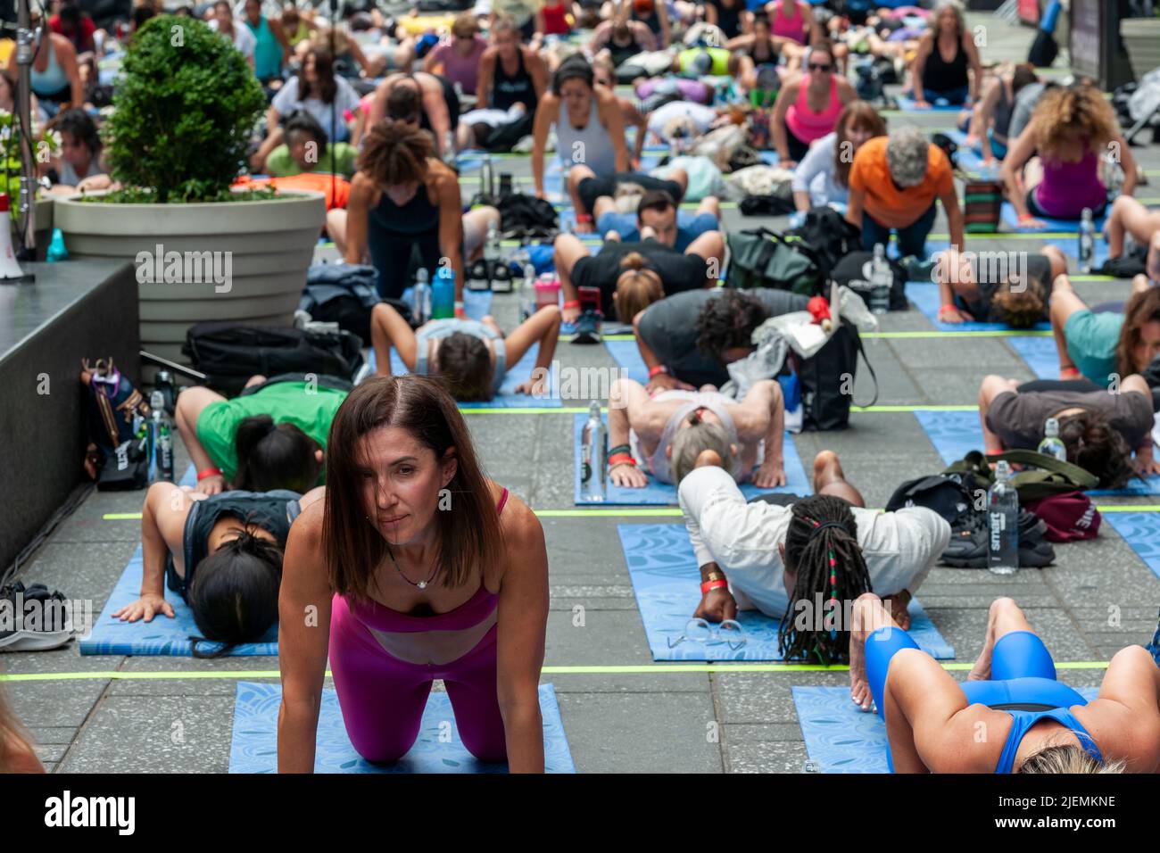 I praticanti di yoga pack Times Square a New York per praticare lo yoga sul solstizio d'estate, primo giorno d'estate, martedì 21 giugno 2022. Il Solstice annuale 20th a Times Square, 'Mind Over Madness', sponsorizzato da Peloton, il Consolato Generale dell'India, New York e Smartwater, tra gli altri, allunga la capacità dello yoga di bloccare il rumore e l'ammasso visivo che li circonda nei Crossroads del mondo. Il primo giorno d'estate è stato dichiarato dalle Nazioni Unite la Giornata Internazionale dello Yoga. (© Richard B. Levine) Foto Stock