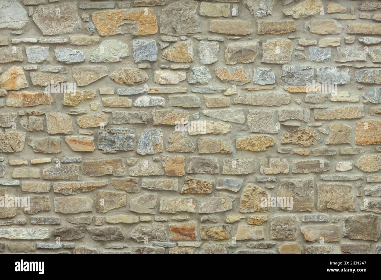Robusto muro in pietra tagliato di giallo e beige, adatto per sfondi Foto Stock