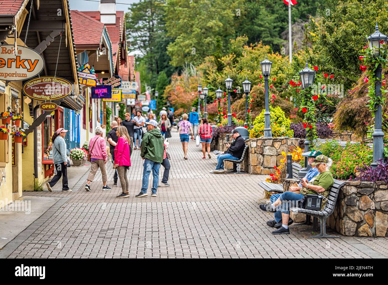 Helen, USA - 5 ottobre 2021: Helen, Georgia villaggio tradizionale edificio di architettura con molti turisti seduti su panchine e segno per Foto Stock