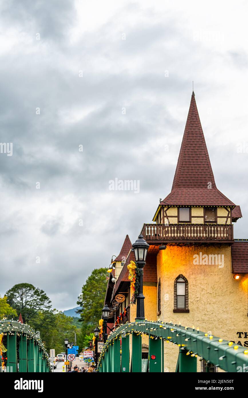Helen, USA - 5 ottobre 2021: Helen, Georgia Ponte illuminato della città bavarese in serata con decorazioni per le vacanze sulla strada principale e la gente sul fianco Foto Stock