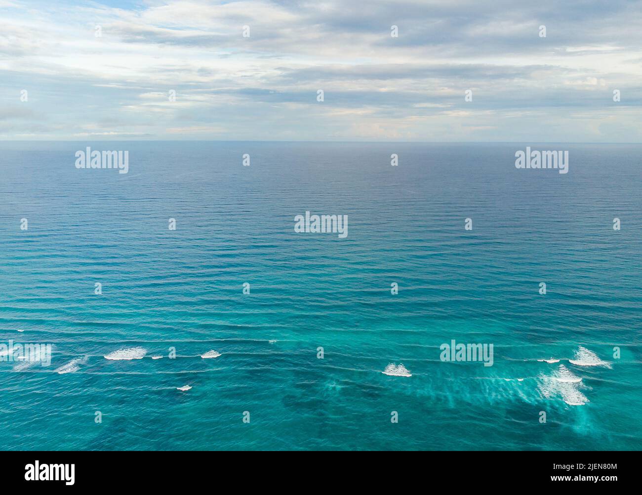 Vista aerea del blu Mar dei Caraibi con piccole onde vicino alla barriera corallina in una giornata trascorsa a Tulum Foto Stock