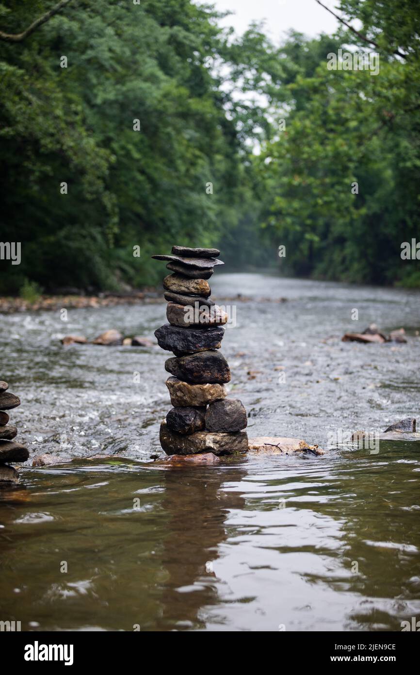 Pietre accatonate con cura sul fiume che scorre dolcemente Foto Stock