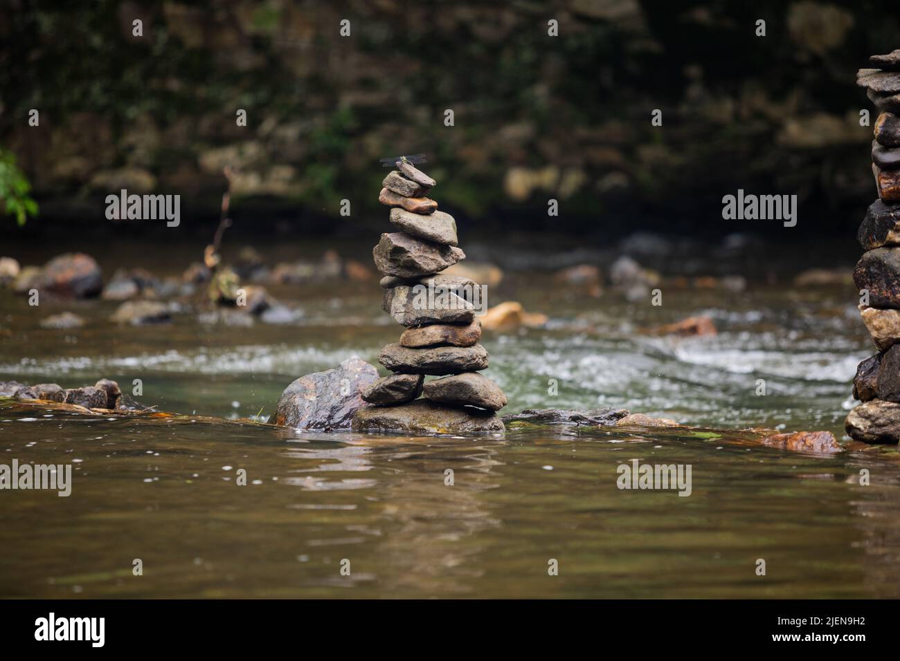 Pietre accatonate con cura sul fiume che scorre dolcemente Foto Stock