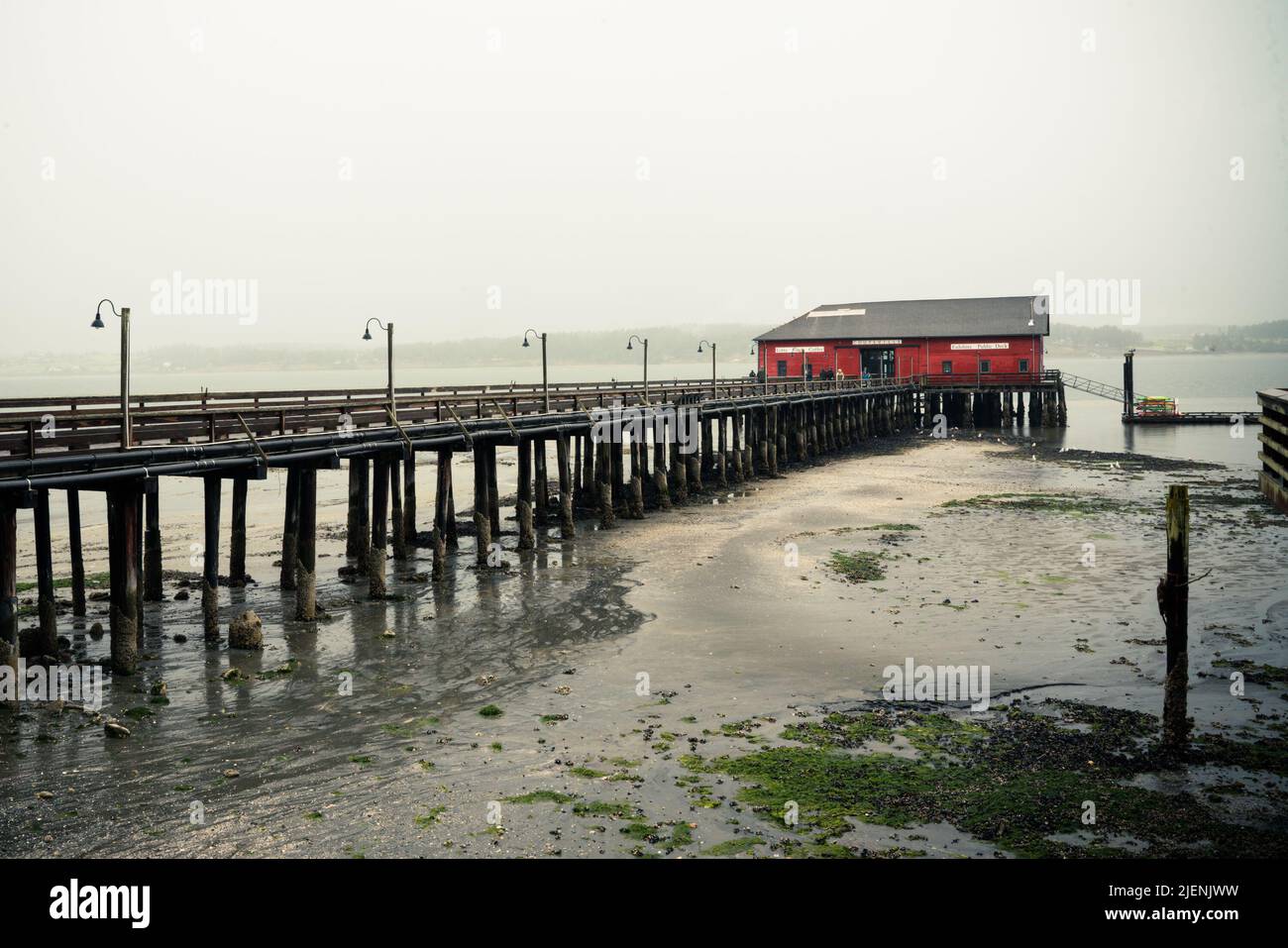 Vista da Coupéville Washington sull'Isola di Whidbey con molo e edificio storico in vista, in una giornata piovosa Foto Stock