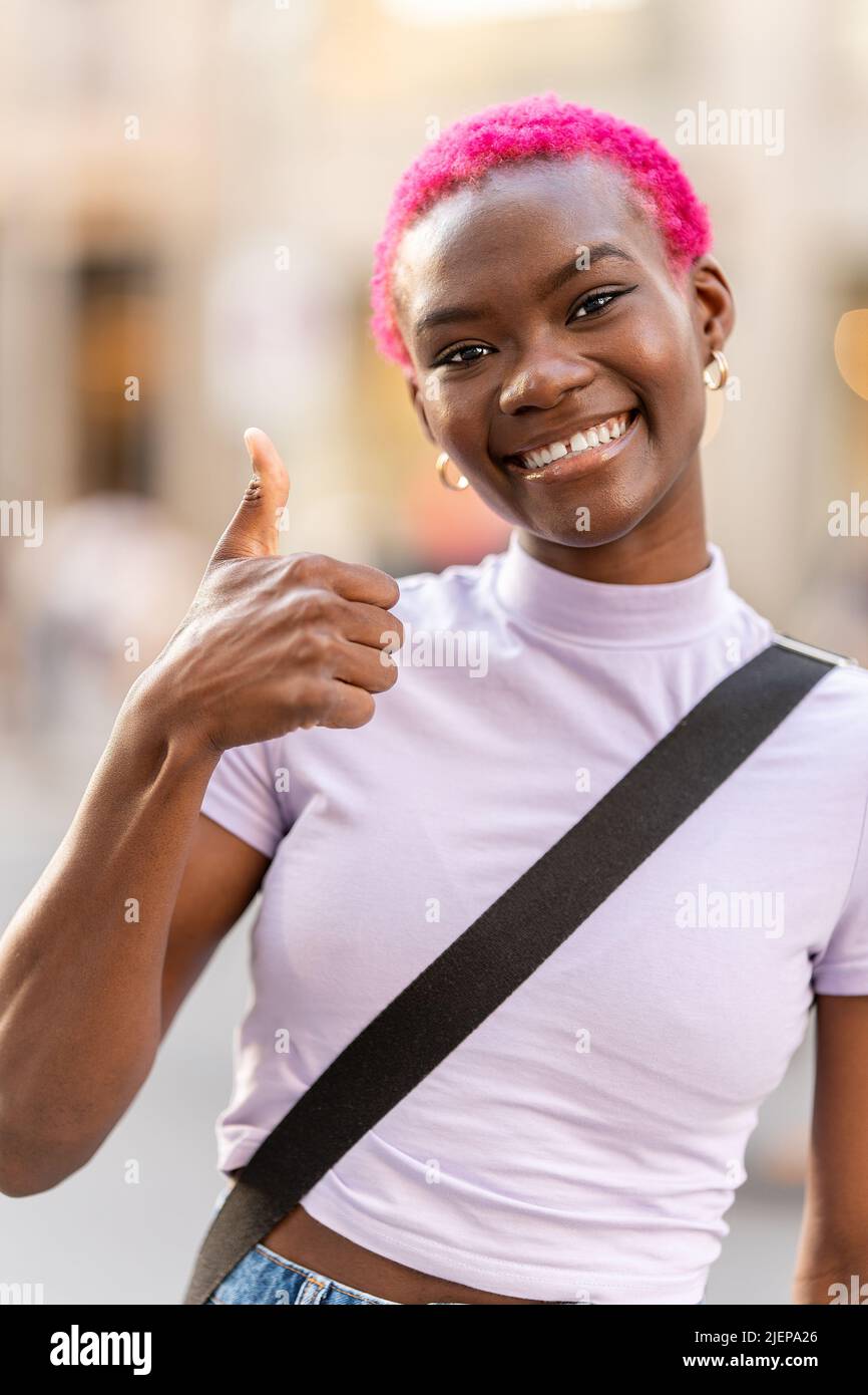 Giovane donna afroche gesturing per essere bella all'aperto Foto Stock