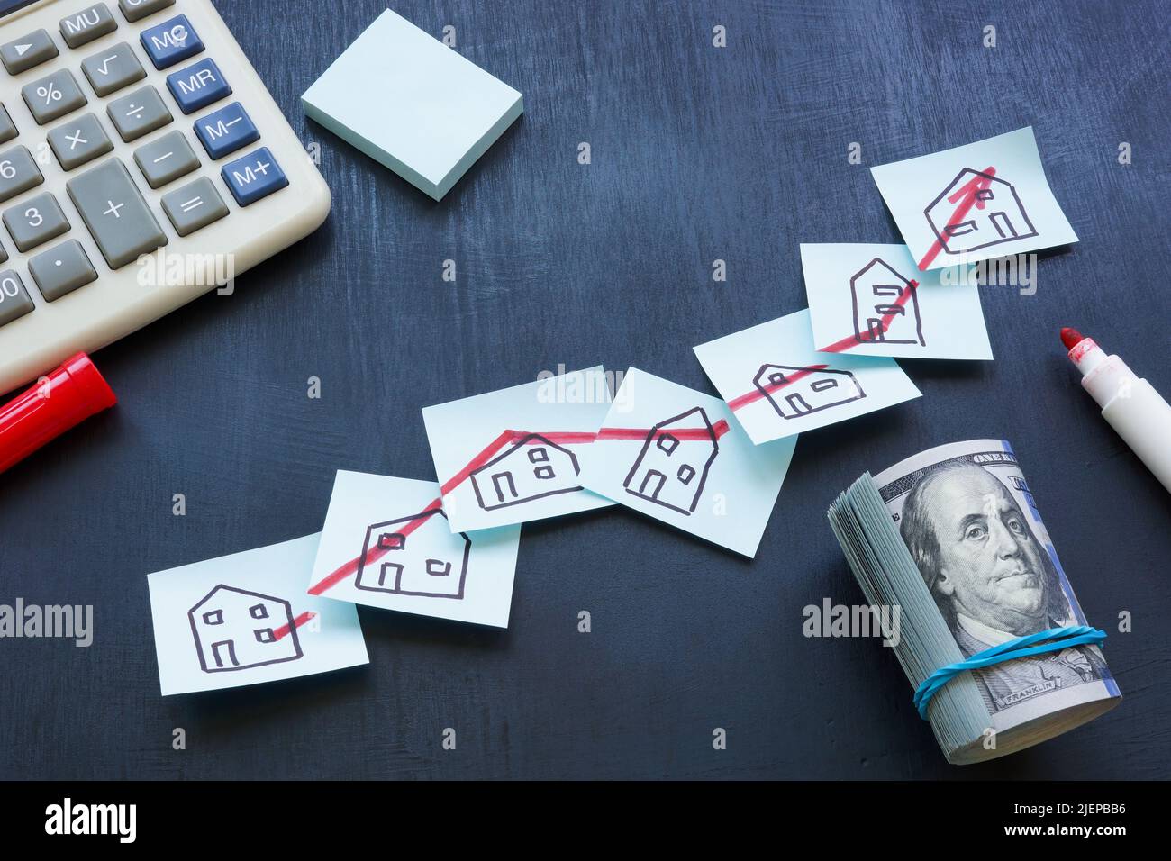 Concetto di investimento immobiliare. Freccia che si alza e disegni di case. Foto Stock