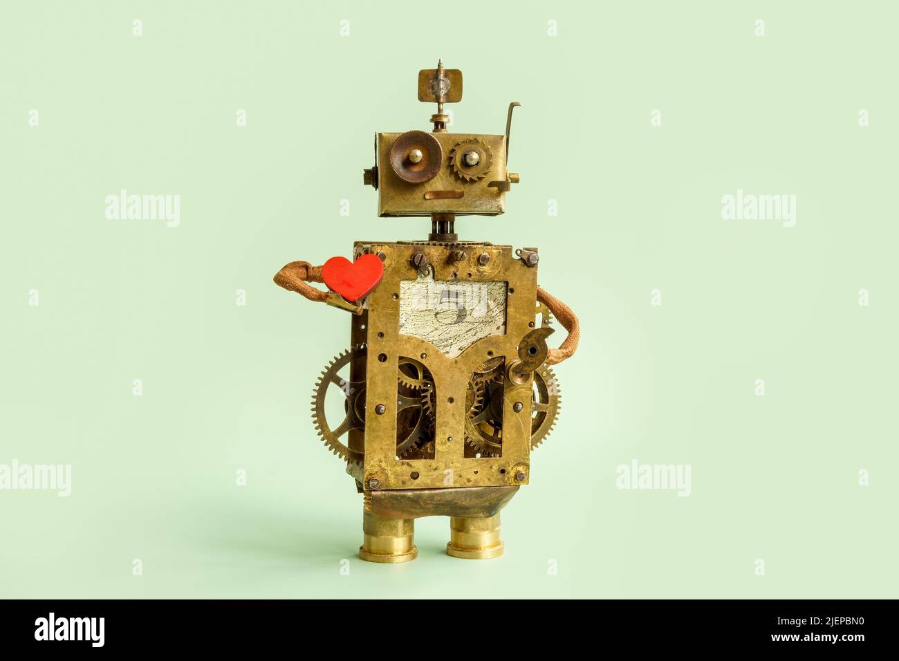 Il vecchio robot sta tenendo un cuore. Concetto di logica ed emozioni. Foto Stock