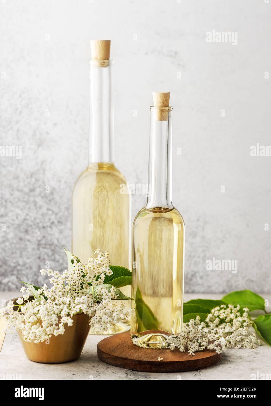 Due bottiglie di vetro di sciroppo di elderflower con germogli di fiori di sambuco. Concetto di cibo fatto in casa. Messa a fuoco selettiva. Spazio di copia. Foto Stock