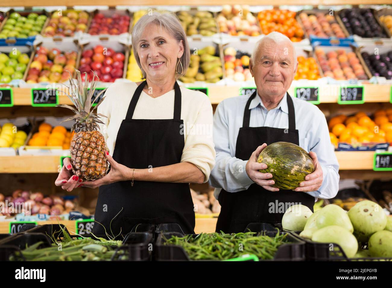 Lavoratori maturi di supermercati in piedi in sala di vendita Foto Stock