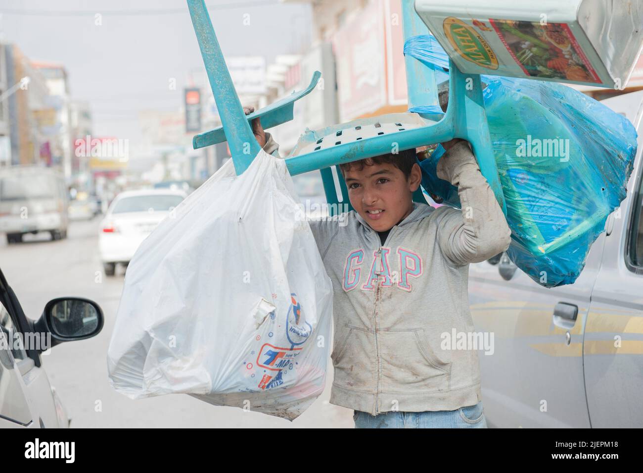 Al Mafraq, Giordania. Molti bambini e adolescenti, spesso rifugiati e migranti provenienti da Siria, Iraq ed Egitto, devono fare duro lavoro per le strade all’interno dell’economia informale per aiutare le loro famiglie a guadagnare un tenore di vita minimo, che spesso scende al di sotto delle soglia di povertà. Foto Stock