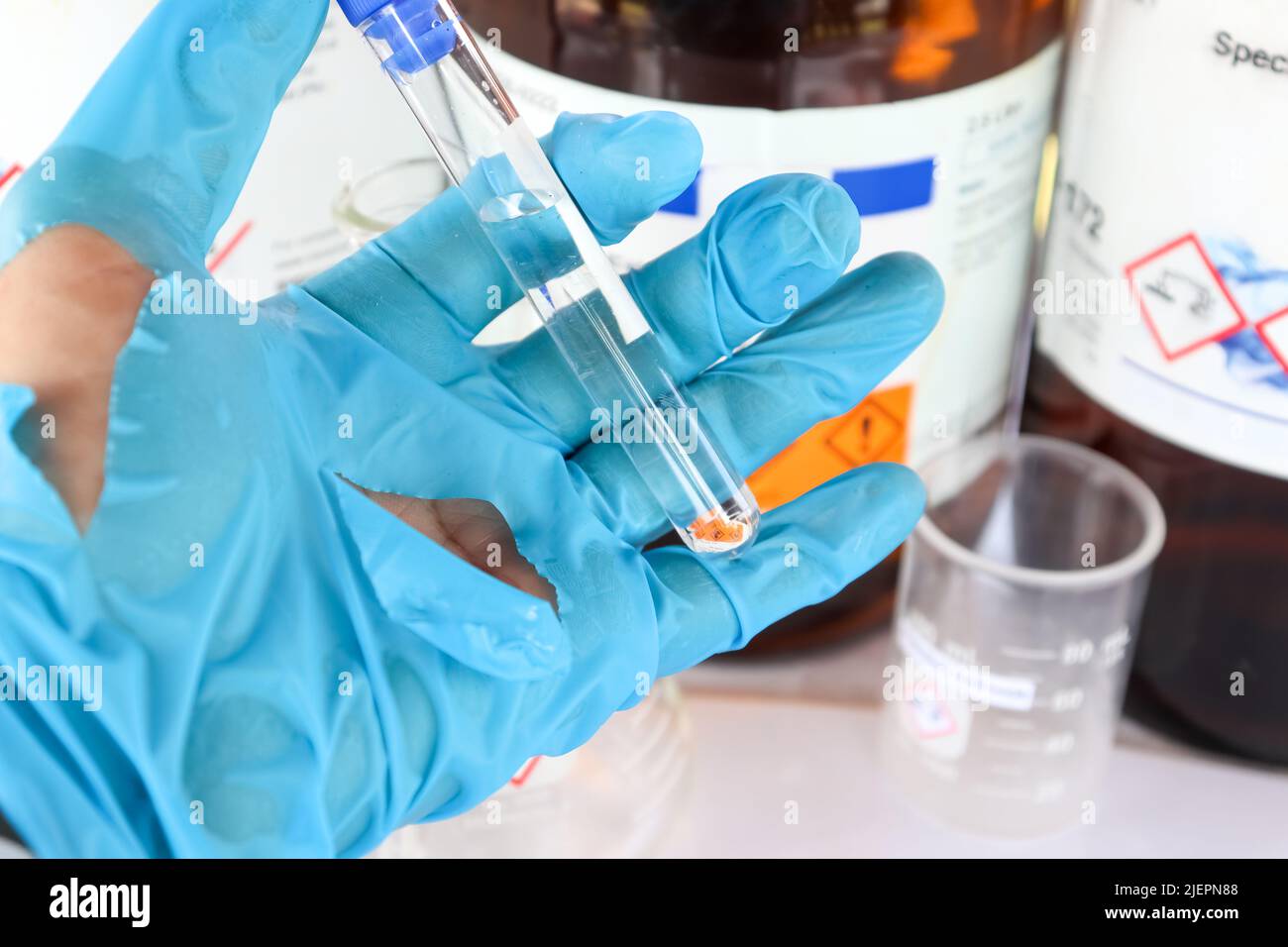 Utilizzare guanti strappati quando si lavora con sostanze chimiche pericolose in laboratorio o nell'industria Foto Stock