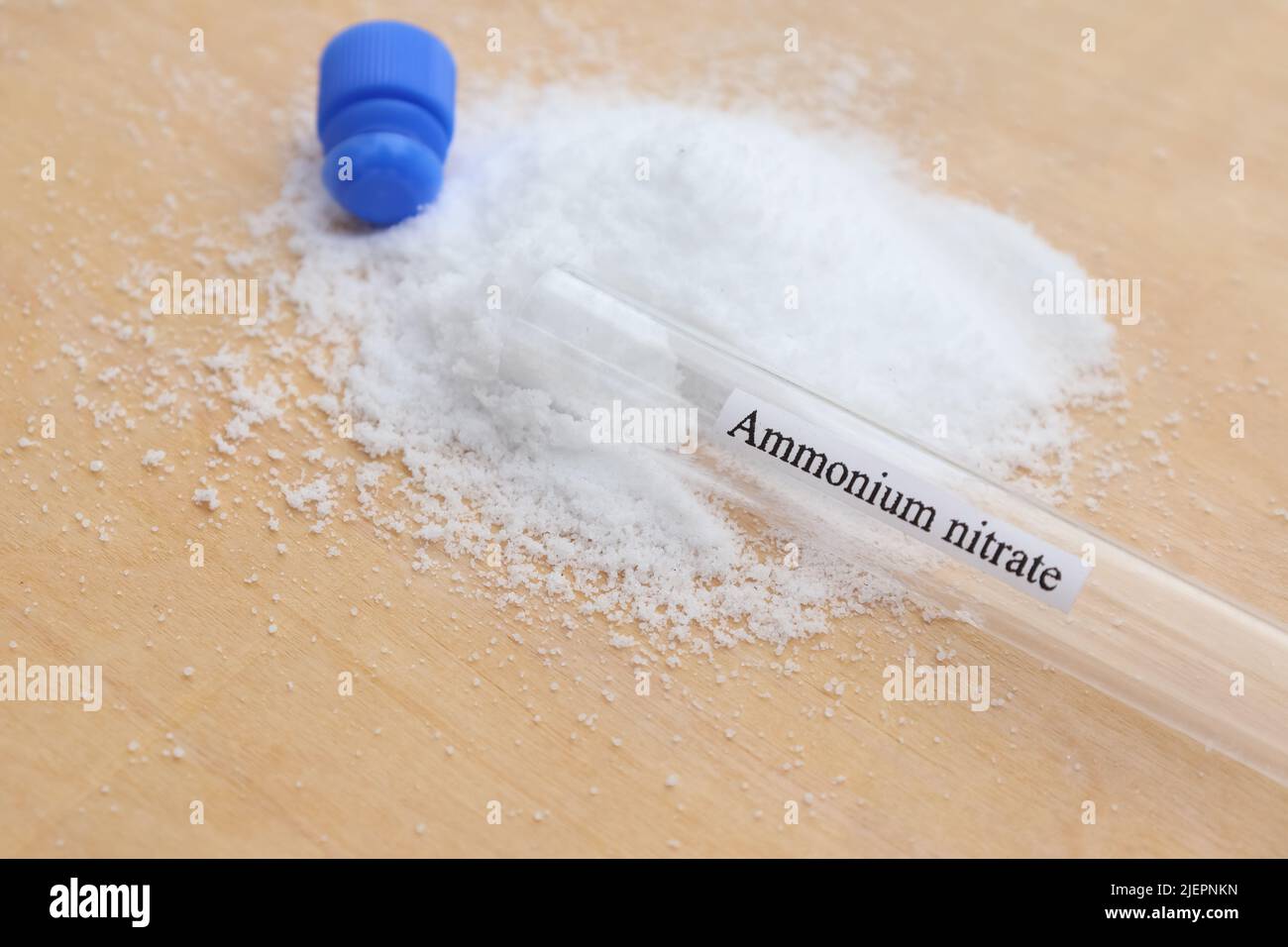 nitrato di ammonio in provetta e fondo in legno Foto Stock