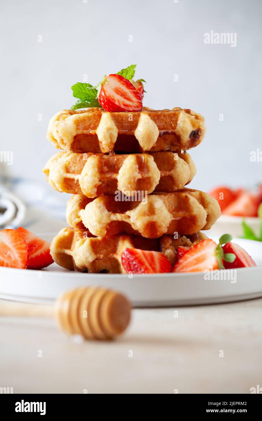 Impila di waffle fatti in casa con fragole biologiche e miele Foto Stock