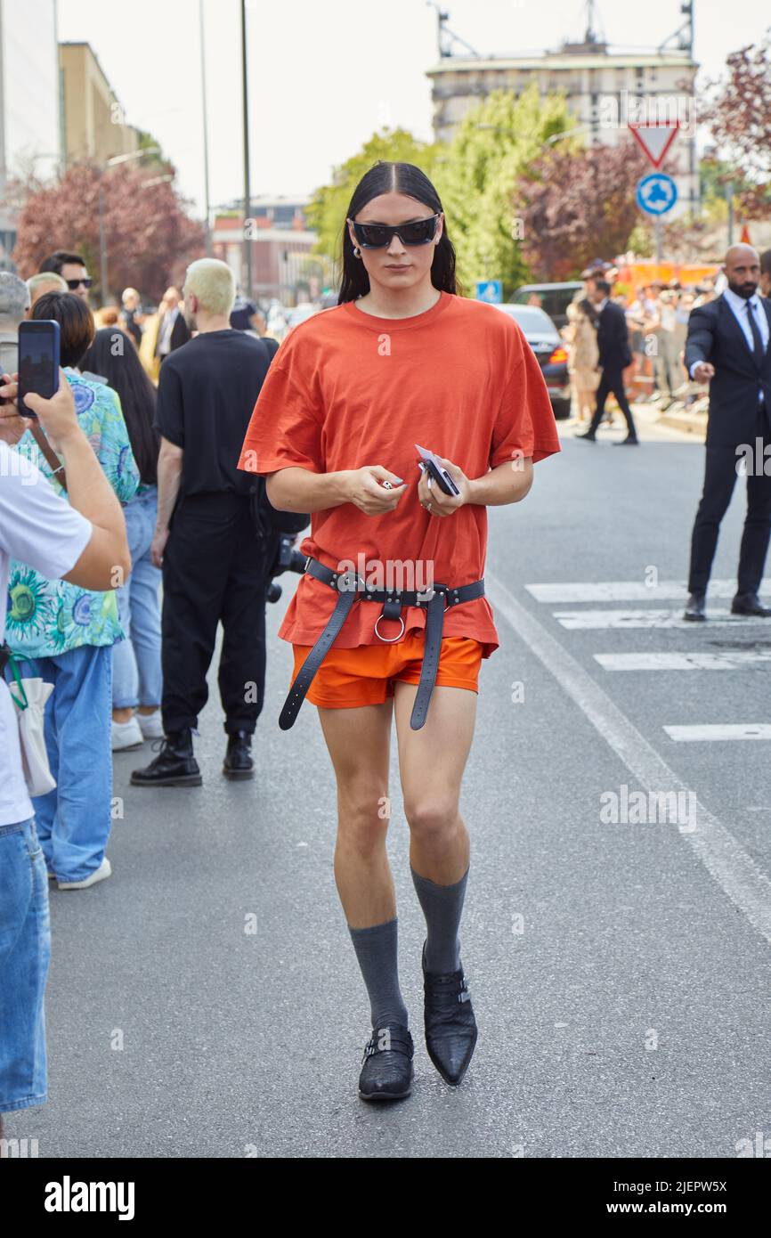 MILANO, ITALIA - 19 GIUGNO 2022: Uomo con maglietta arancione e pantaloncini e cintura in pelle nera prima della sfilata di moda Prada, Street style della settimana della Moda di Milano Foto Stock