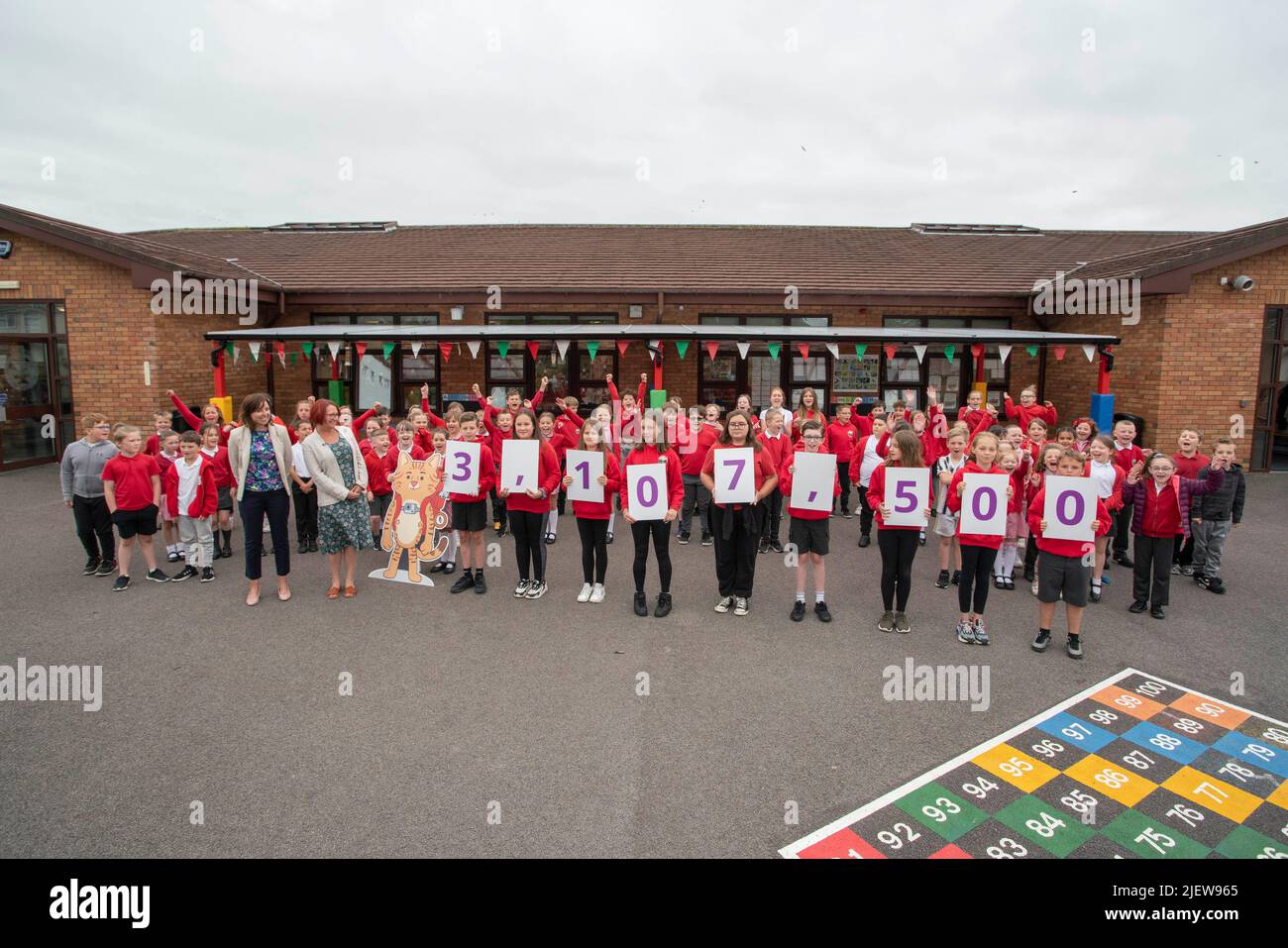 USO EDITORIALE SOLO gli alunni della scuola elementare Tonyrefail di Rhondda hanno appostato cartelli numerici per annunciare il censimento 2021 popolazione del Galles dall'Ufficio per le statistiche nazionali del 3.107.500. Data foto: Martedì 28 giugno 2022. Foto Stock