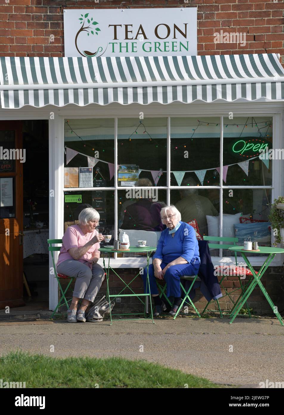 due donne più grandi che prendono il tè fuori dal negozio di tè tradizionale clare suffolk inghilterra Foto Stock