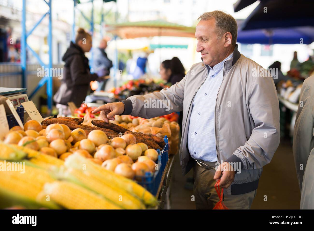 Uomo che sceglie le verdure in greengrocery Foto Stock