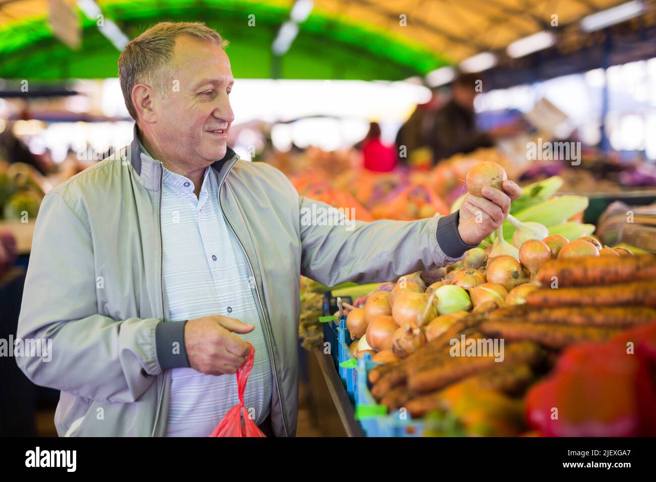 Uomo di mezza età che acquista cipolle Foto Stock