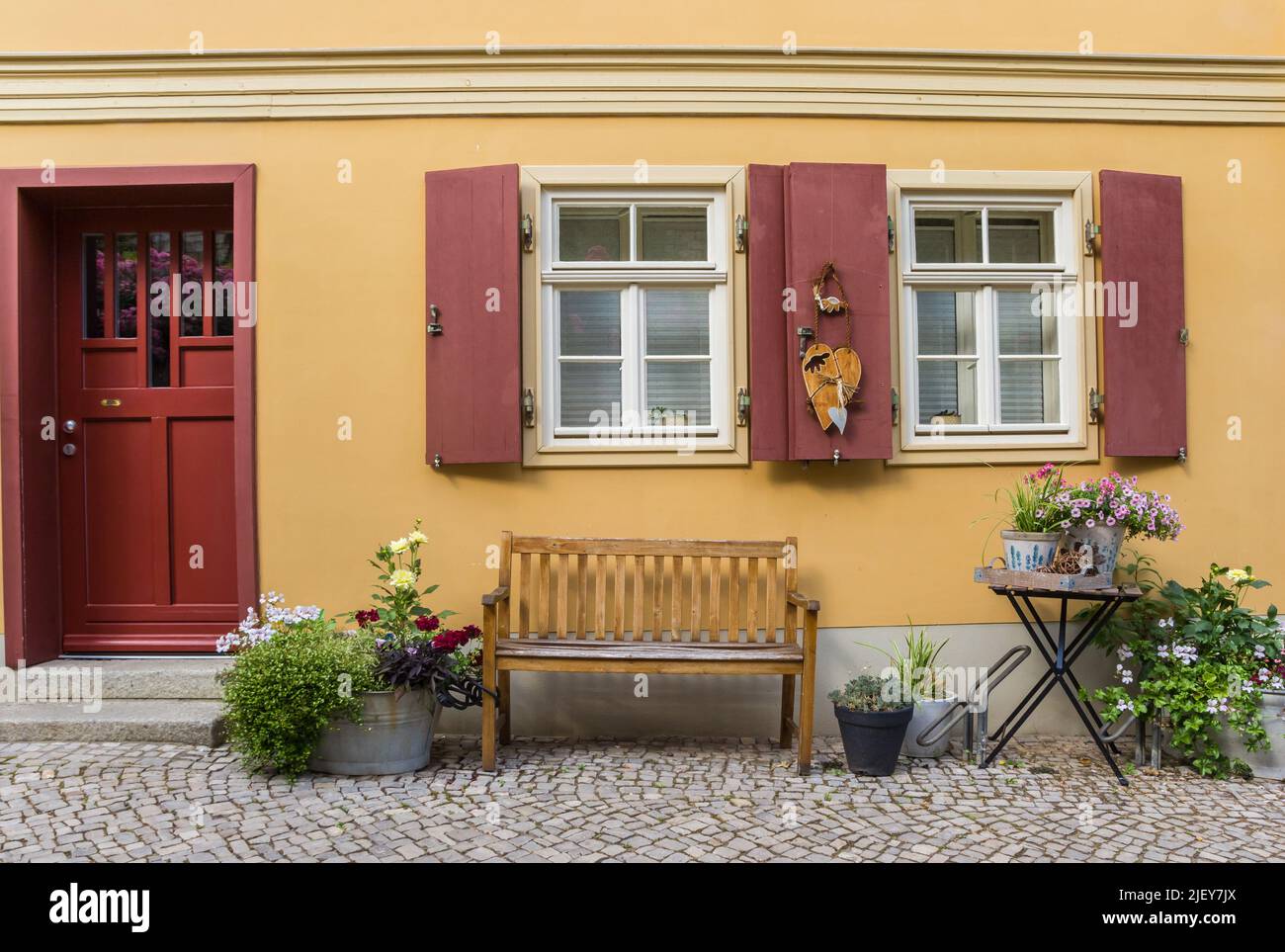 Panca e fiori di fronte a una vecchia casa a Quedlinburg, Germania Foto Stock