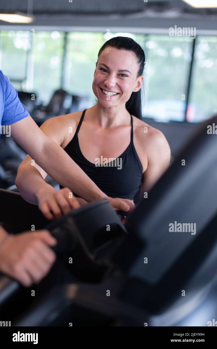 Buon giovane caucasico personal trainer Toothy sorriso al tapis roulant Foto Stock