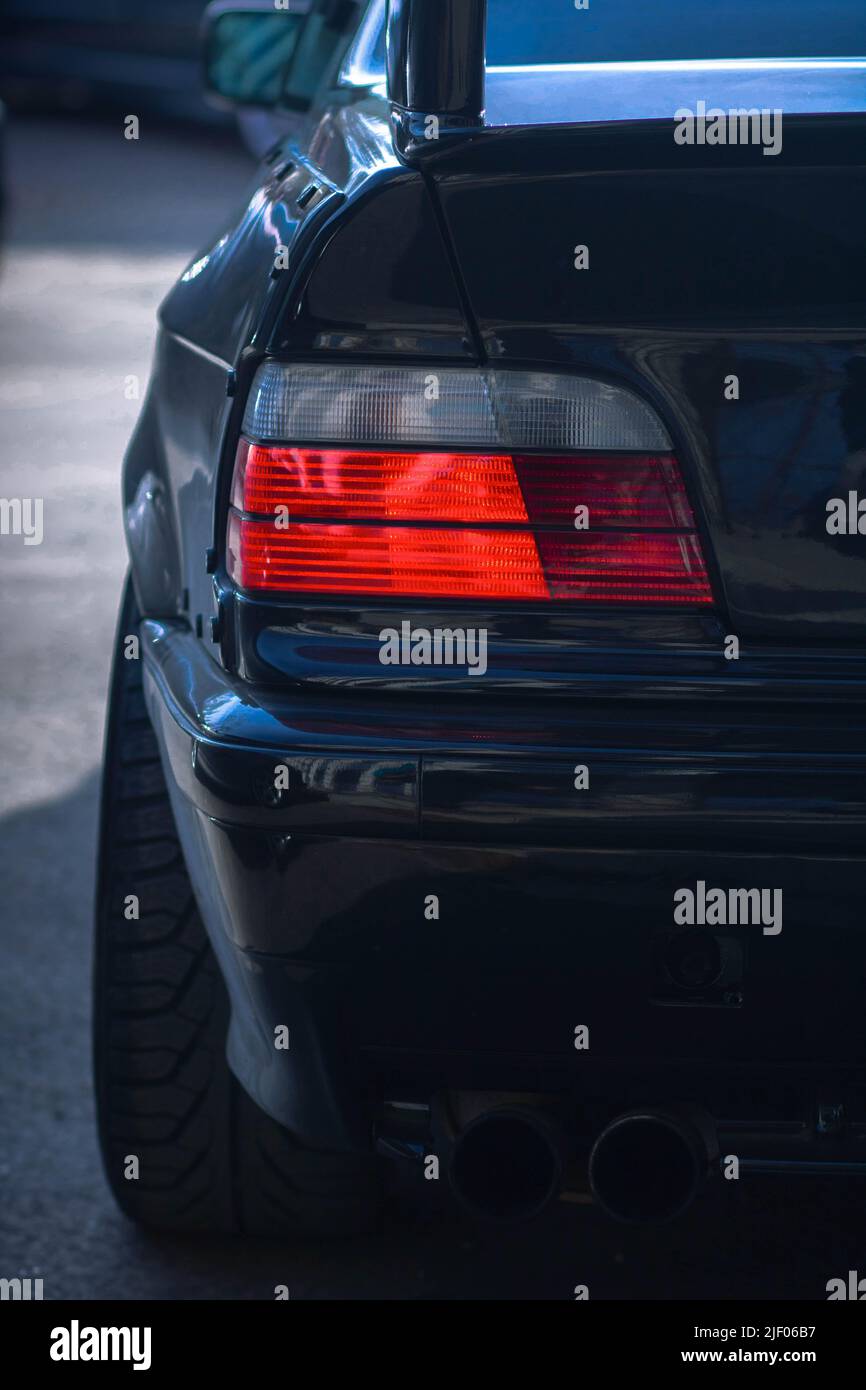 Un primo piano verticale del fanalino di coda nero dell'auto. Foto Stock