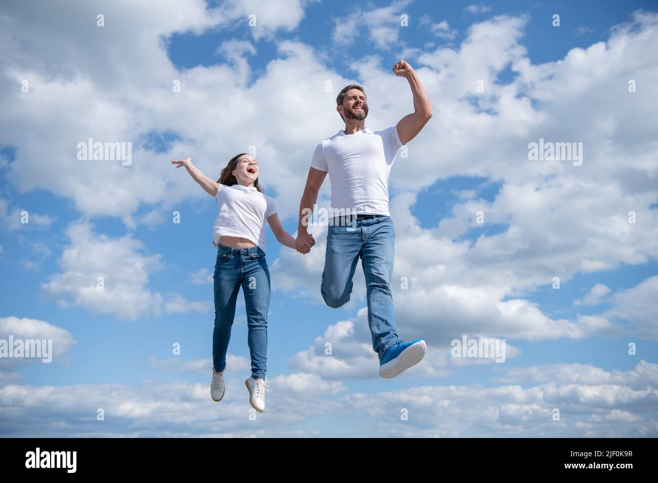 spensierato padre e figlia saltano in cielo Foto Stock