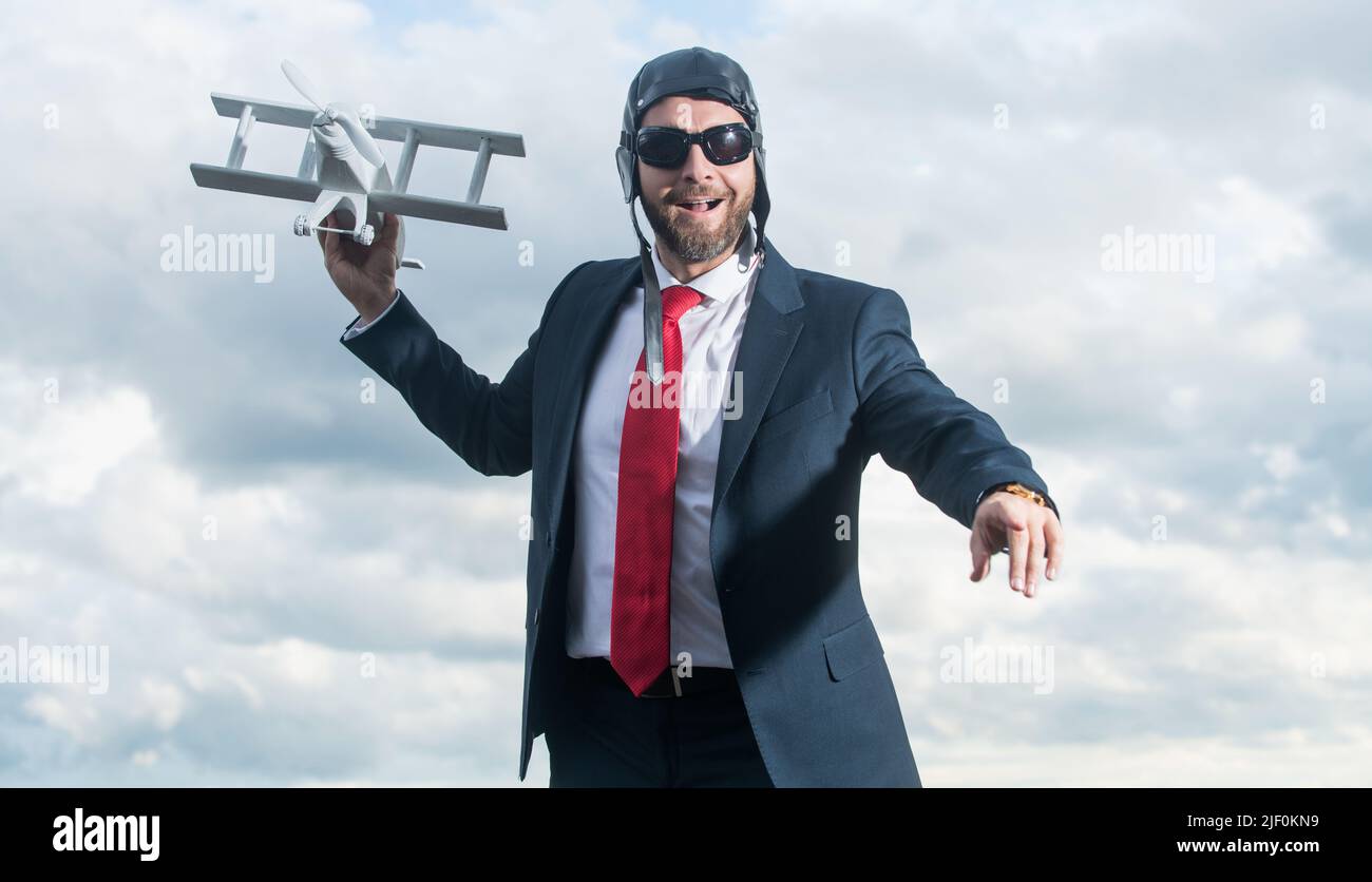 uomo d'affari in abito e cappello pilota lancia giocattolo aereo. obiettivo aziendale Foto Stock