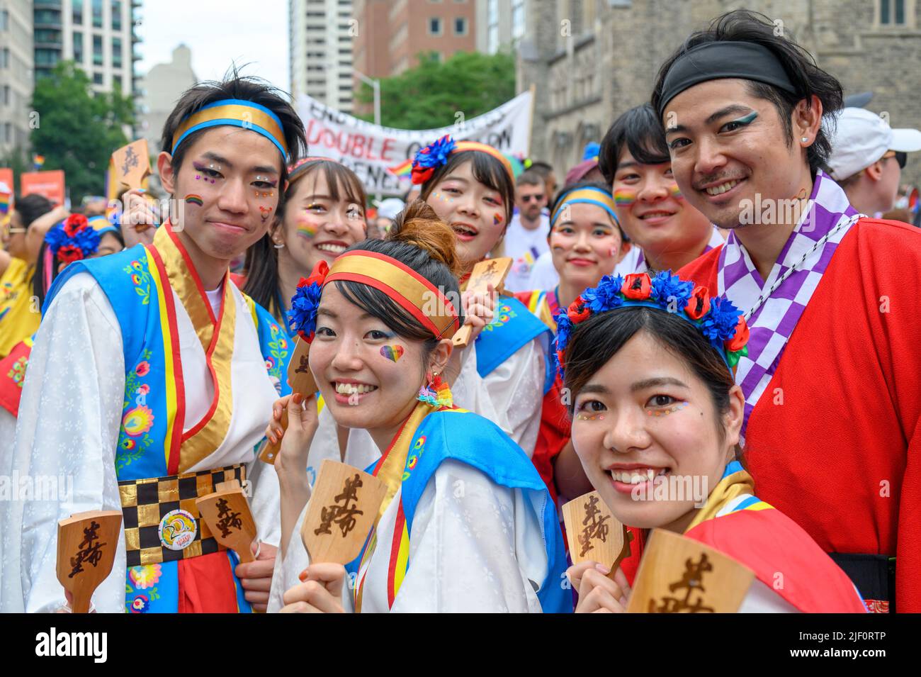 Gruppo di persone di discendenza asiatica che indossano abiti colorati durante la Pride Parade Foto Stock
