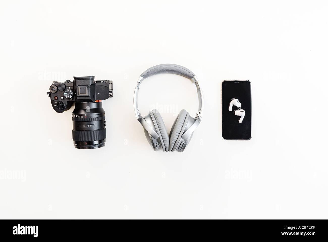 Fotocamera, cuffie, telefono allineati Foto Stock