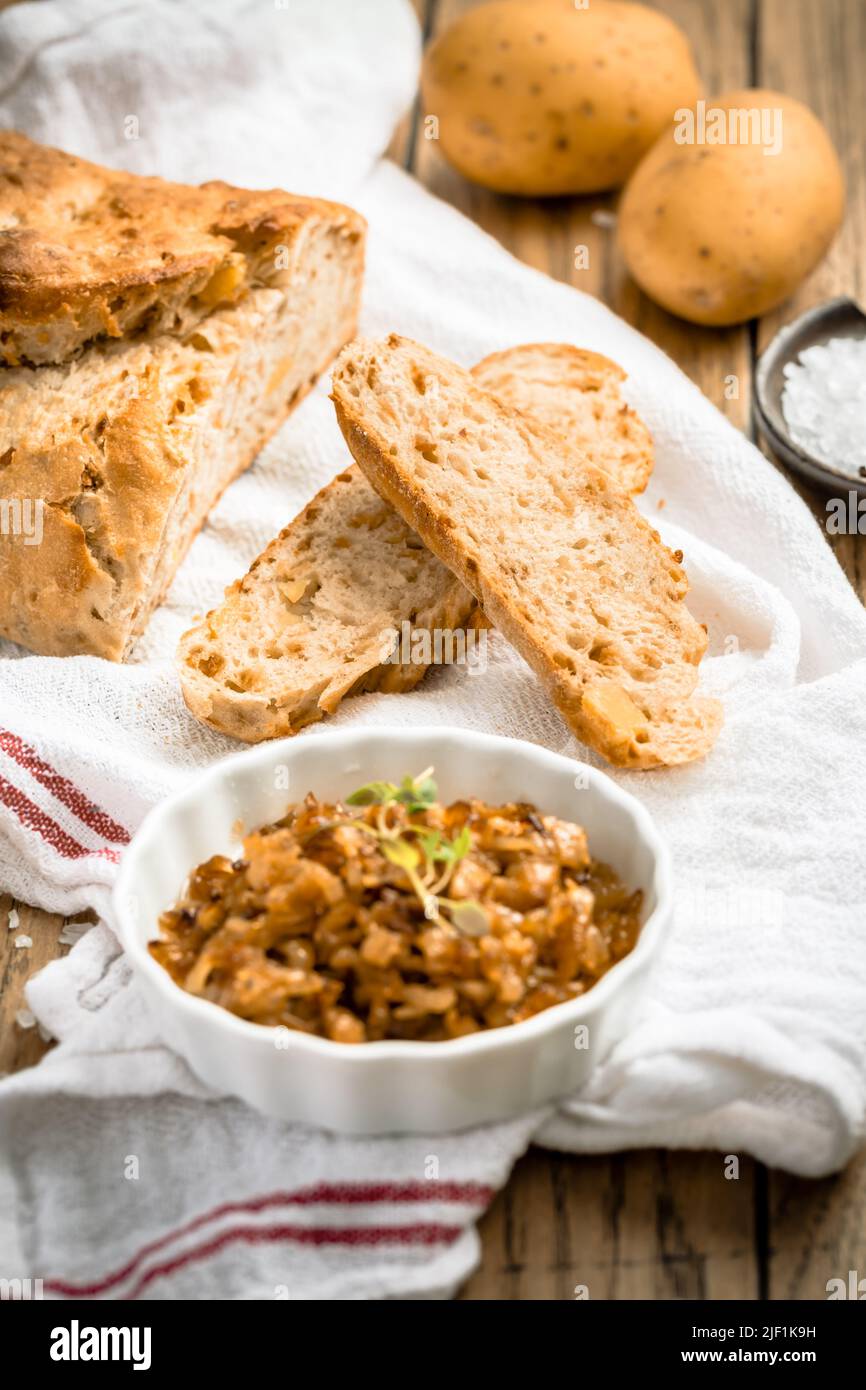 Pane di patate con farina di farro e cipolle tostate su tavola di legno Foto Stock