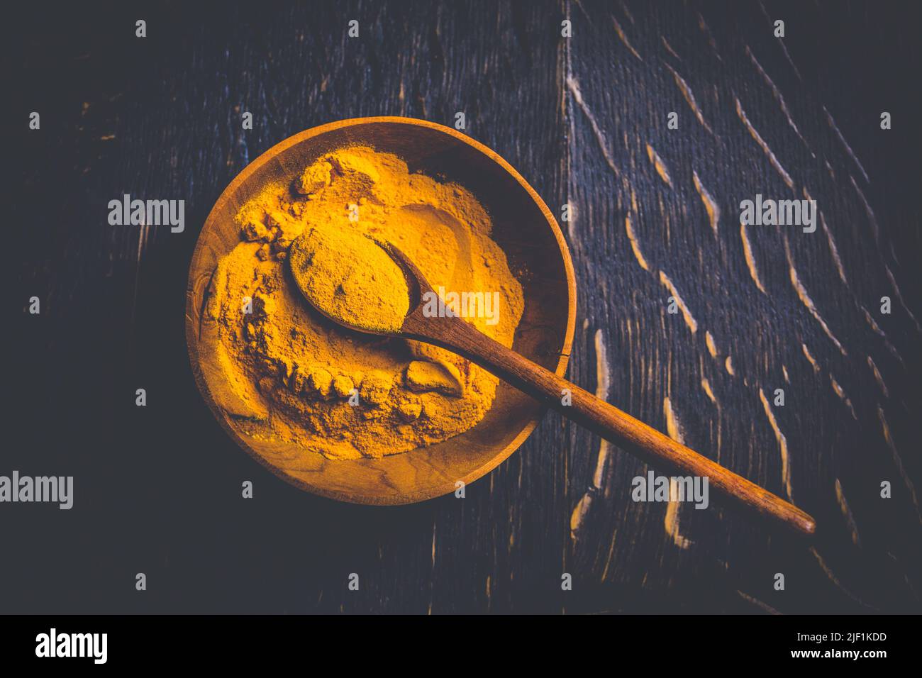 Curcuma in polvere indiana, curcuma in ciotola piccola con cucchiaio, Haldi in polvere su sfondo di legno Foto Stock