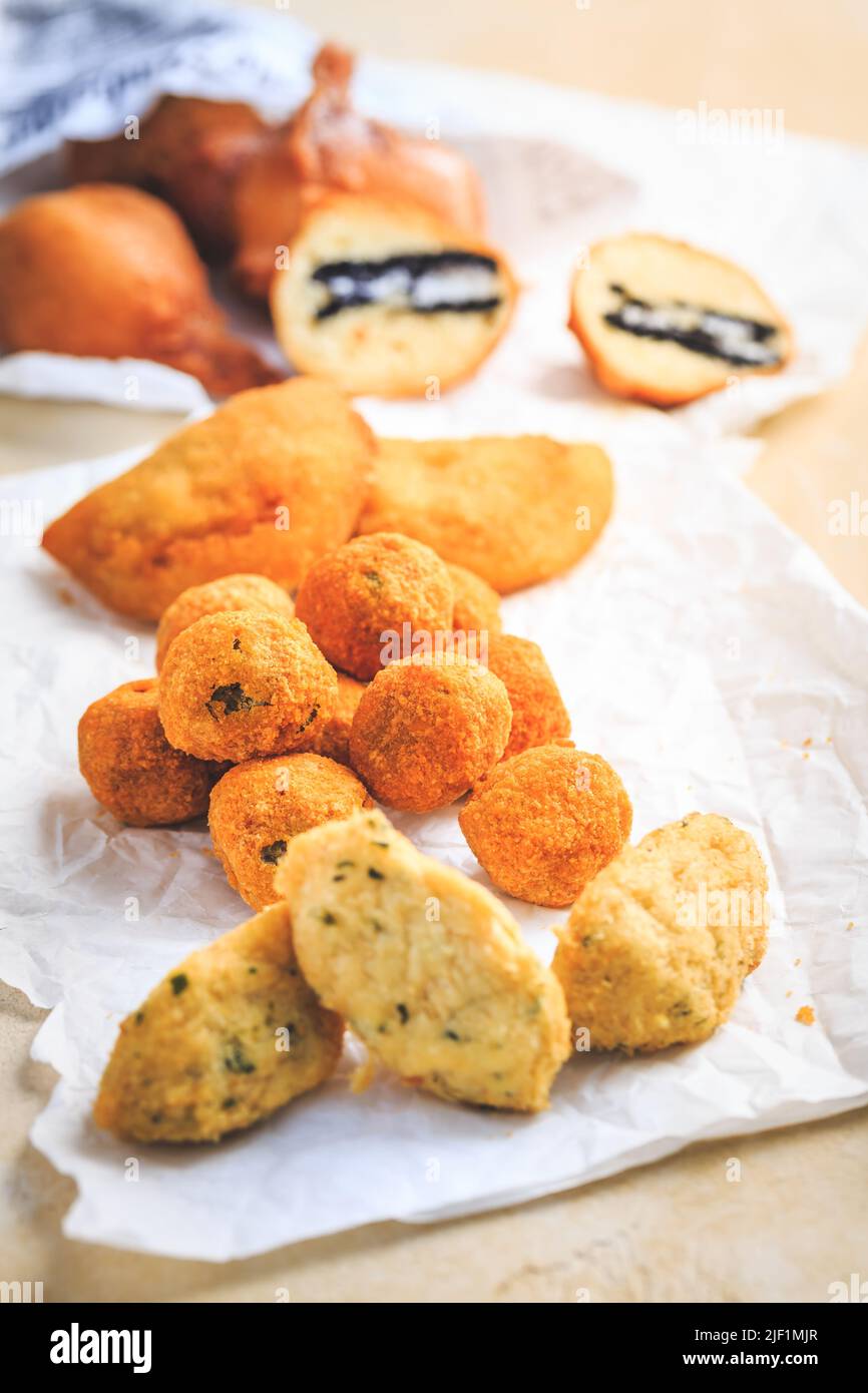 Finger food e Street food - assortimento di palle di riso Arancini, palle di curd fritte, torte di merluzzo Foto Stock