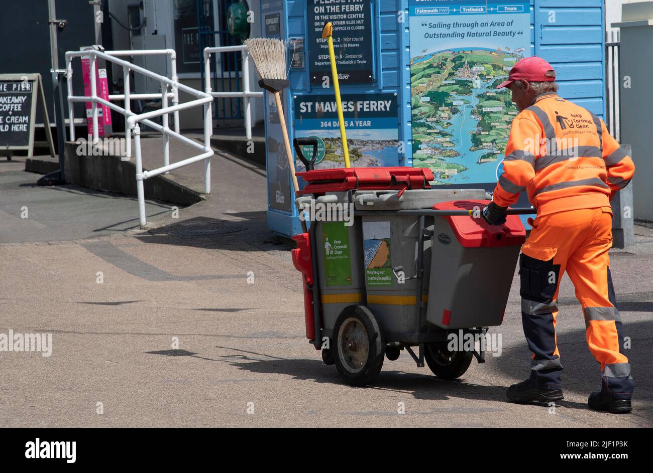 Falmouth Harbour, Cornovaglia, Inghilterra, Regno Unito. 2022. Pulitore di strada con il suo carrello e bidoni sulla zona di fronte al mare a Falmouth, Regno Unito. Foto Stock
