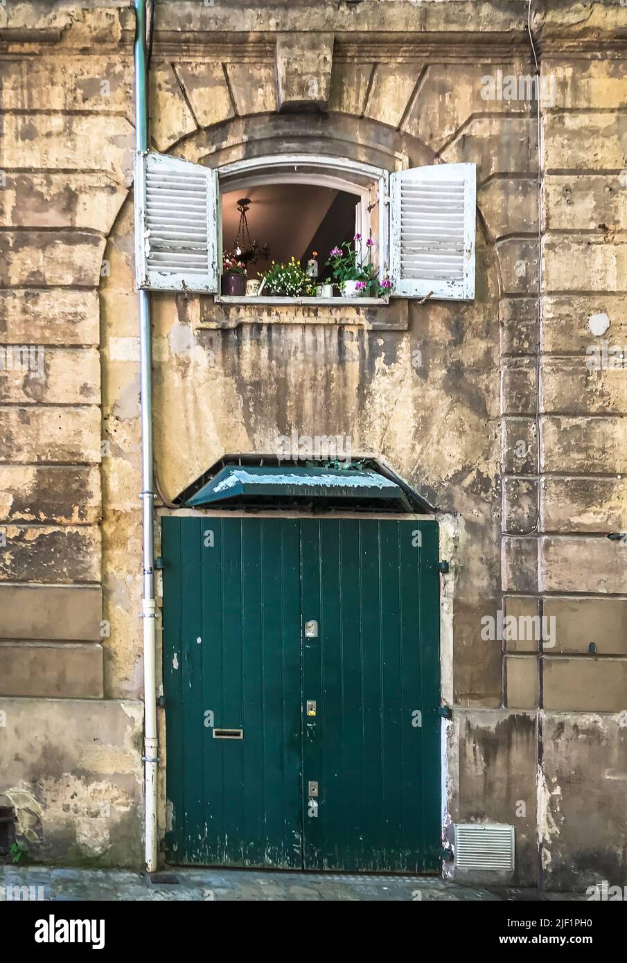 Aix-en-Provence, Francia, maggio 2022, vista di un edificio calcareo con persiane verdi chiuse e una finestra aperta Foto Stock