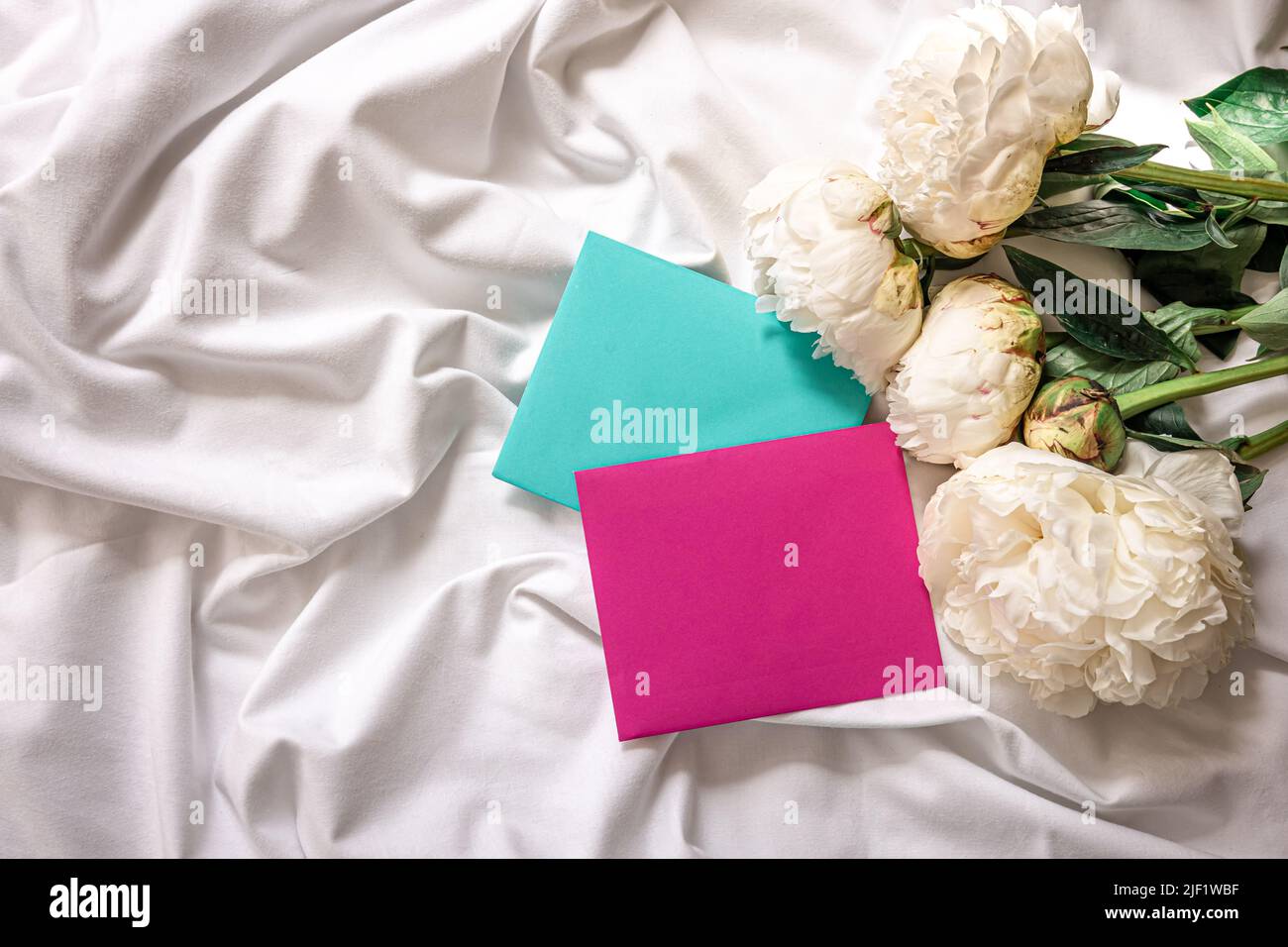Sfondo con fiori peonie e buste a letto. Foto Stock
