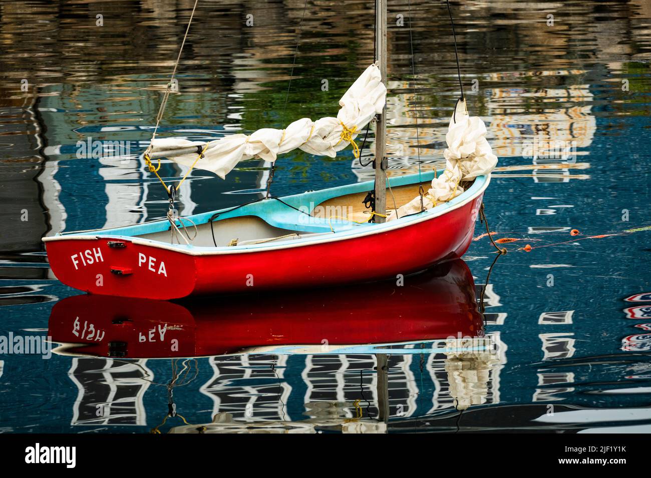 La piccola barca a vela si riflette sulle calme acque del Porto di Lunenburg, Nuova Scozia, Canada. Foto Stock