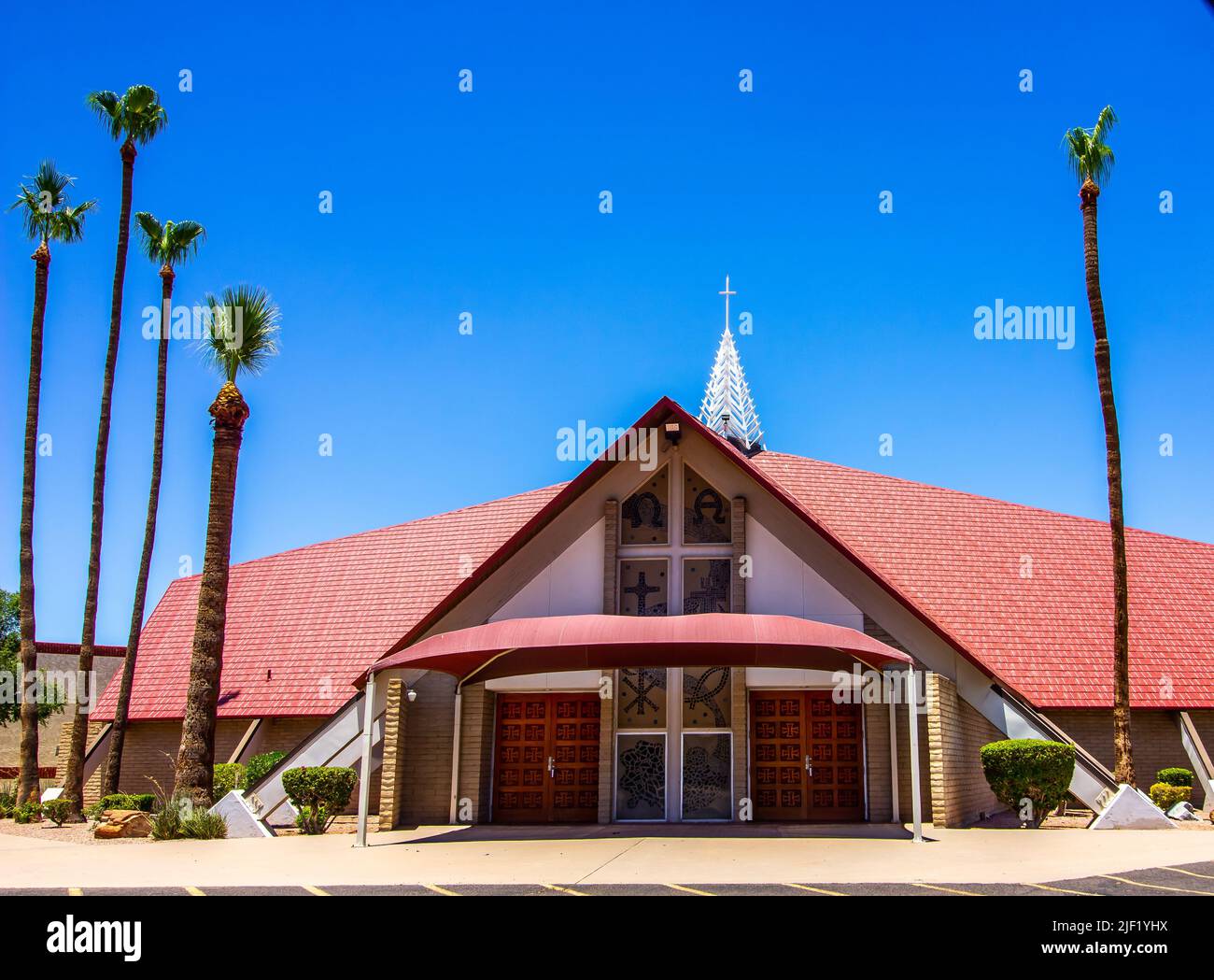 Chiesa moderna con vetrate colorate e alberi di palma Tall Foto Stock