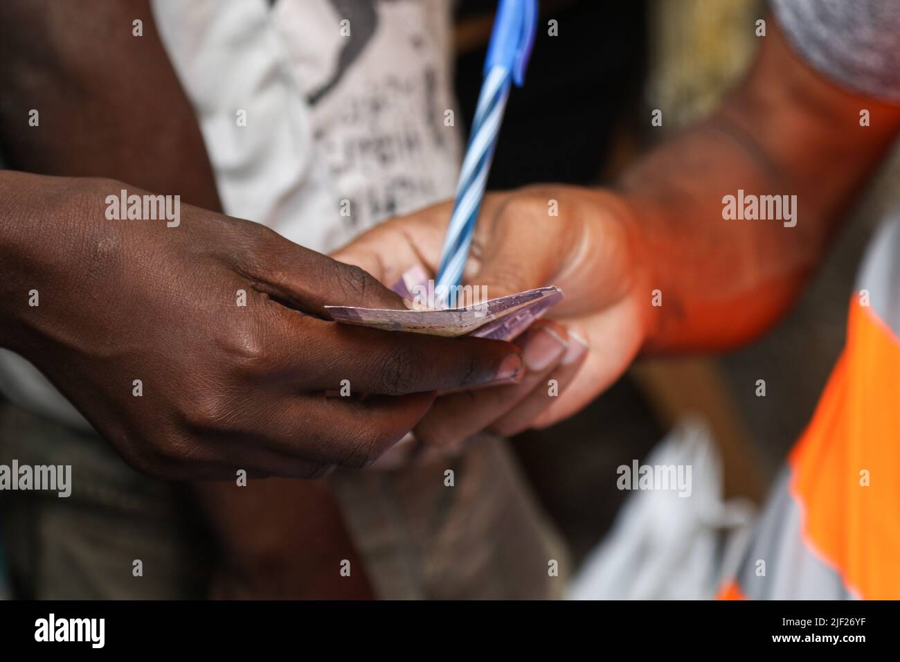 I membri di un gruppo comunitario per l'ambiente, Weka Lamu Safi (Keep Lamu Clean), ricevono pagamenti in contanti per i rifiuti di plastica che hanno venduto all'organizzazione FlipFlopi per il riciclaggio. Nel 2019 l'Organizzazione FlipFoppi costruisce una barca a vela quasi interamente da rifiuti di plastica riciclata raccolti dalle rive dell'Oceano Indiano. L'inquinamento da attività umane ha avuto un impatto negativo sugli oceani. Il presidente keniota Uhuru Kenyatta nel suo discorso durante la conferenza oceanica in corso a Lisbona, il Portogallo ha detto che l'inquinamento plastico sta falciforme e contaminando almeno 700 specie di vita marina e ha chiamato fo Foto Stock