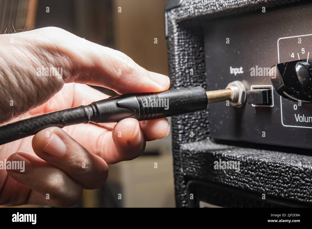 Collegamento di un cavo dello strumento a un amplificatore per chitarra Foto Stock