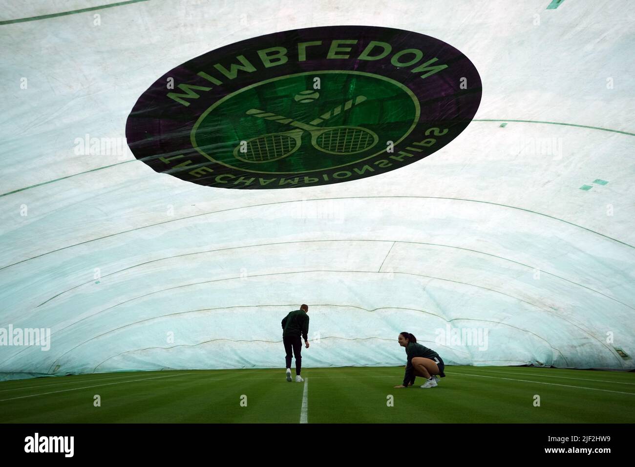 Il personale di terra controlla i campi esterni coperti prima del terzo giorno dei campionati Wimbledon 2022 all'All England Lawn Tennis and Croquet Club di Wimbledon. Data foto: Mercoledì 29 giugno 2022. Foto Stock