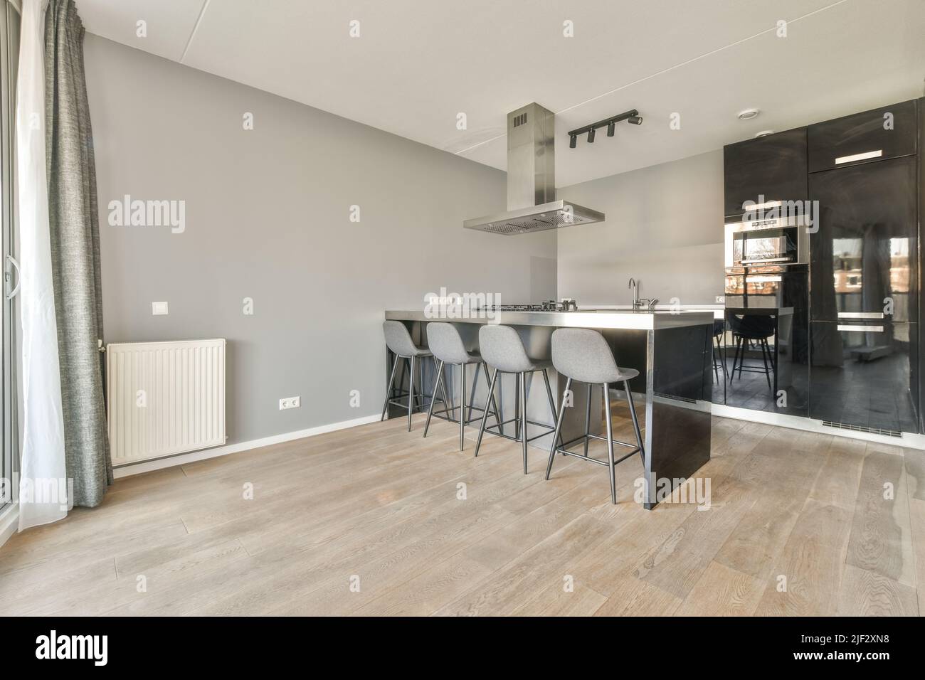 Interni di design moderno loft con cucina a vista in stile minimalista e spaziosa zona pranzo con tavolo e. sedie Foto Stock