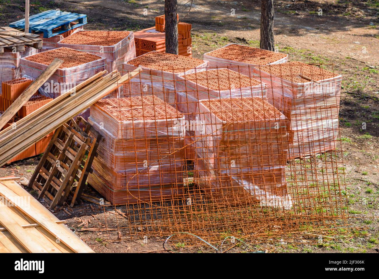 Materiale da costruzione in cantiere - assi, blocchi e tegole, vista ad angolo alto Foto Stock