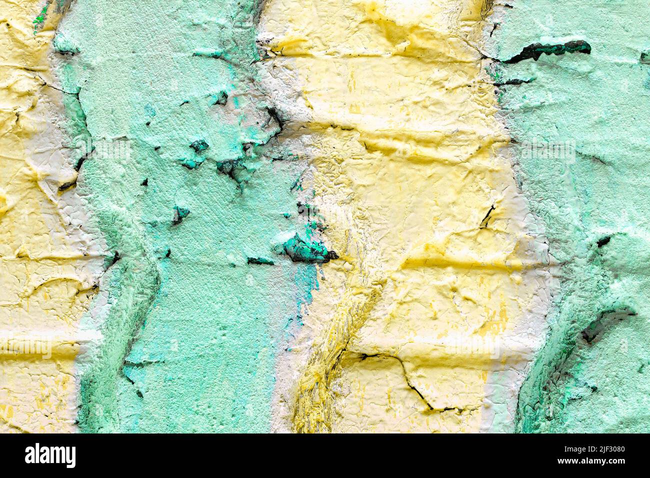 La struttura superficiale di un vecchio pneumatico usato con crepe da un camion auto è dipinta con strisce di pastello verde e giallo. Primo piano luminoso estate co Foto Stock