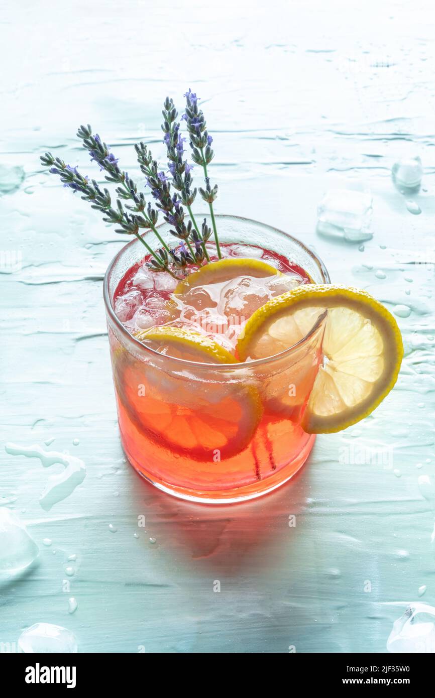 Cocktail estivo o mocktail, una bevanda fresca con limone e lavanda, una rinfrescante limonata party su sfondo blu con ghiaccio Foto Stock