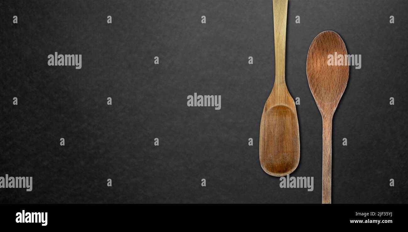 Vista dall'alto di cucchiai di legno da cucina su sfondo scuro Foto Stock