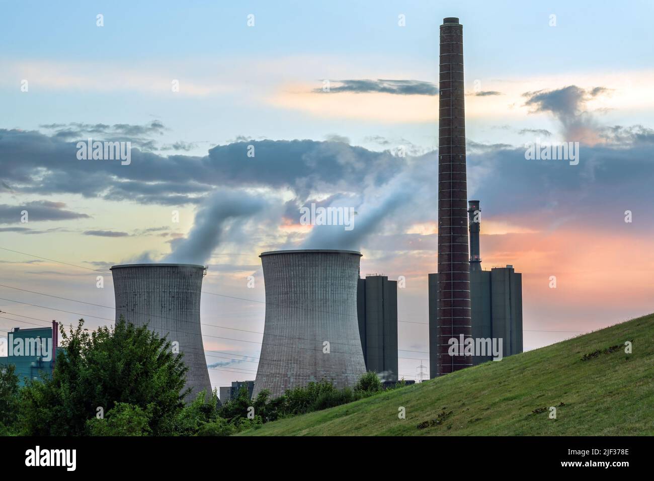 Industria di centrali pesanti, camino e torri con inquinamento alla acciaieria HKM a Duisburg, Germania contro un cielo nuvoloso al tramonto, spazio copia, s Foto Stock