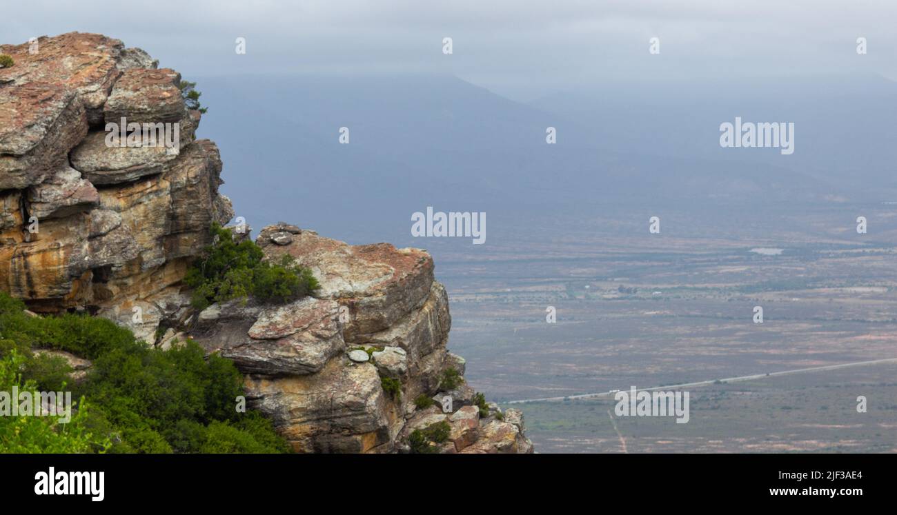 Guardando verso il basso dal Passo Vannhyns vicino a Nieuwoudtville in Sud Africa con rocce nel terreno foroso sul lato sinistro Foto Stock