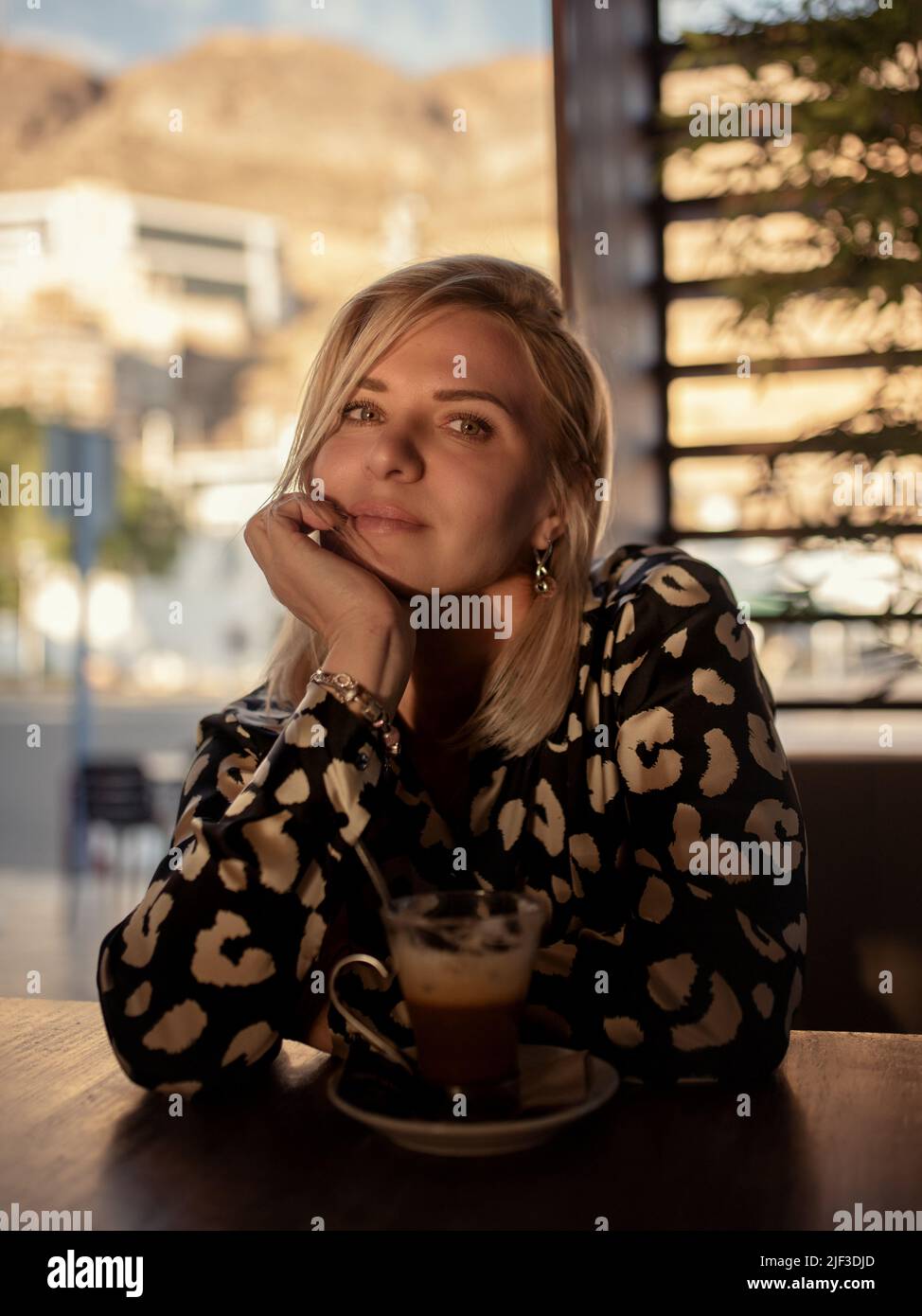 La signora attraente gode di una tazza di caffè nella caffetteria. Foto Stock